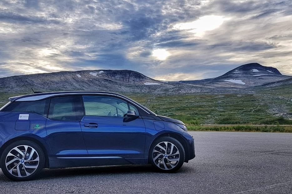 Blue BMW i3 against stunning mountain backdrop in Norway