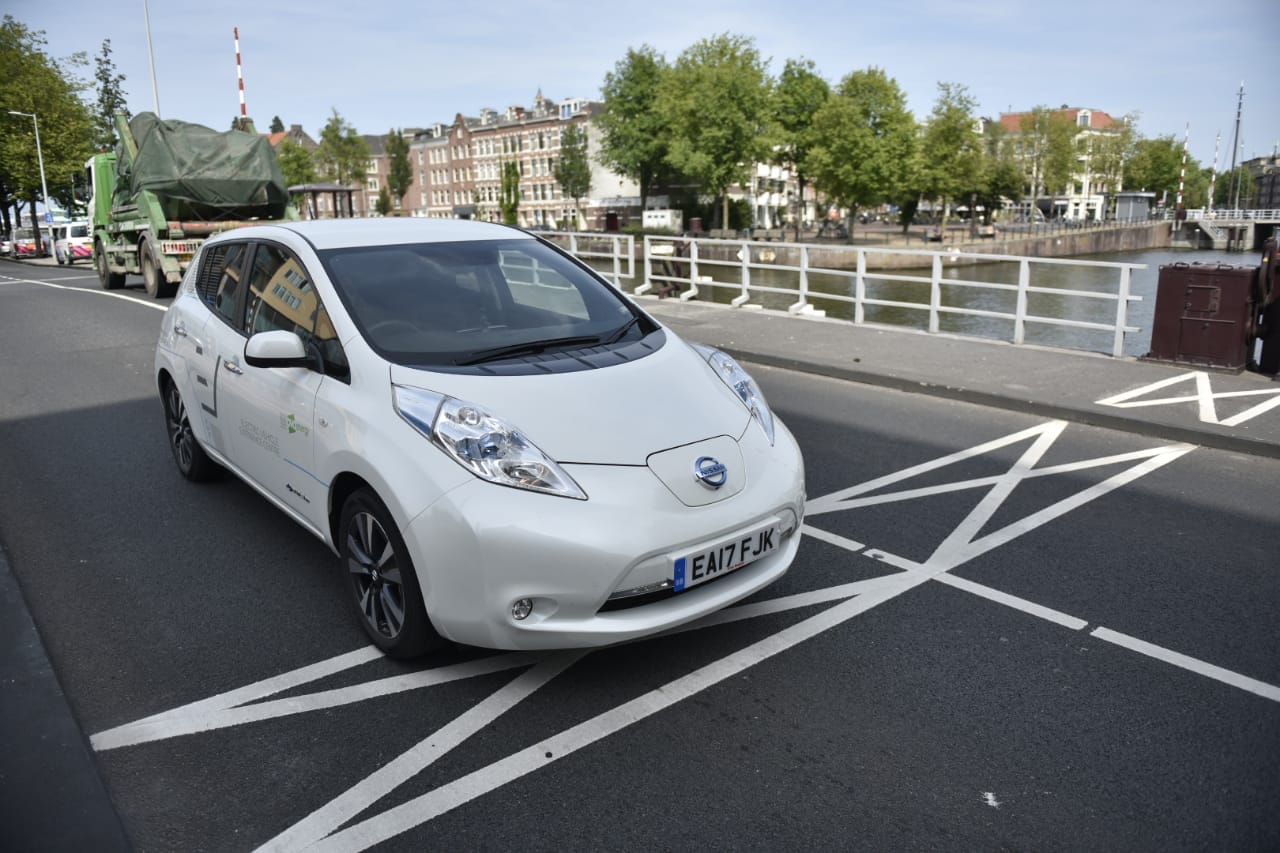 White Nissan Leaf crossing a bridge in Amsterdam