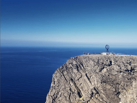 Nordkapp, the most northerly point on mainland Europe.  Monument atop steep cliffs, people at guard rails.